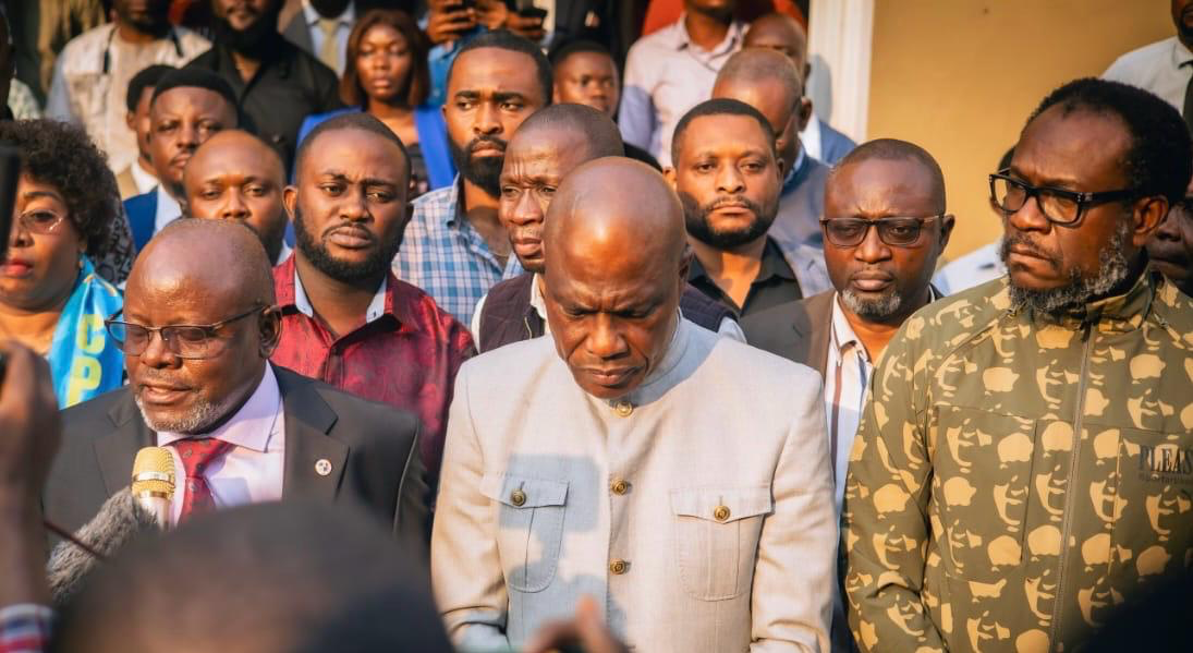 Dr. Justin B. Mudekereza standing among community representatives at a public gathering